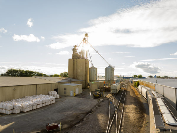 Aerial of Twin Falls, Idaho mill. The sun is shining behind the mill with a partially cloudy sky.